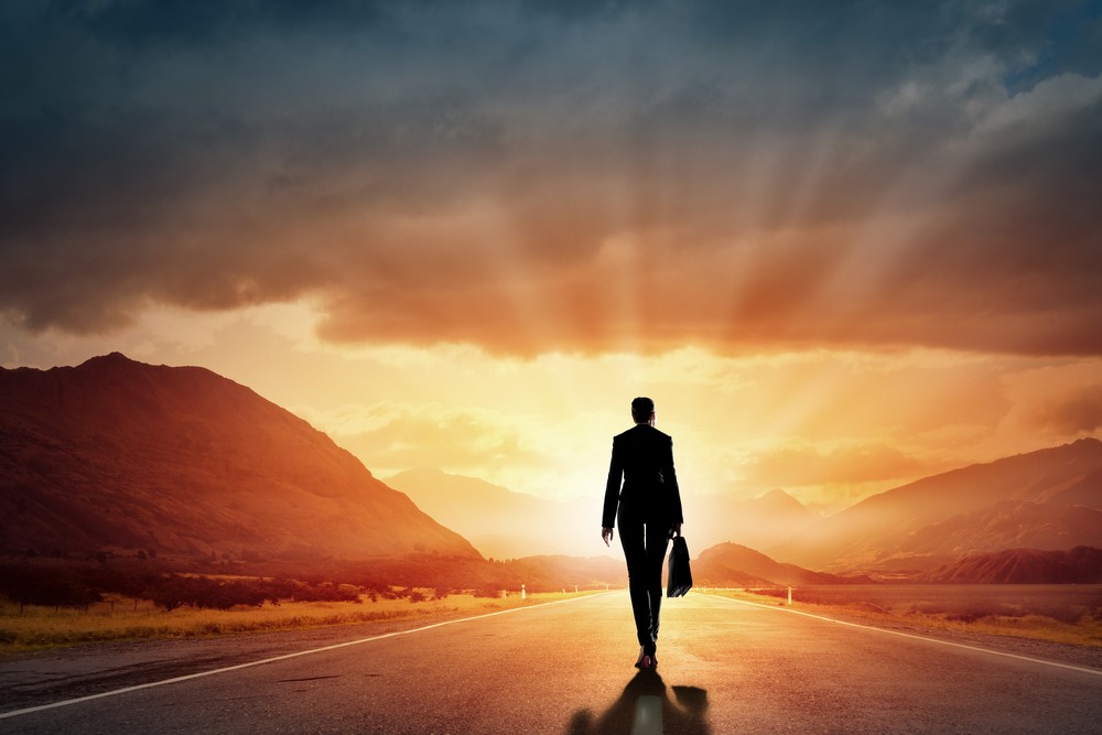 Homem de negócios caminhando em direção ao sol